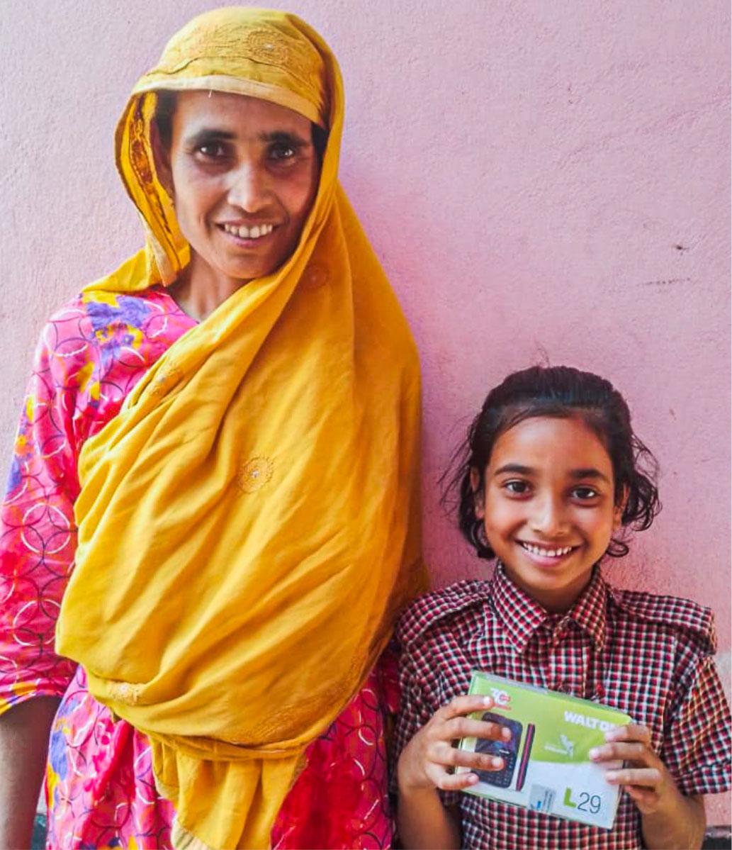 Picture of a student holding a mobile phone in her hand alongside her mother